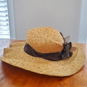 Womens broad brimmed straw hat with decorative brown ribbon and flowers